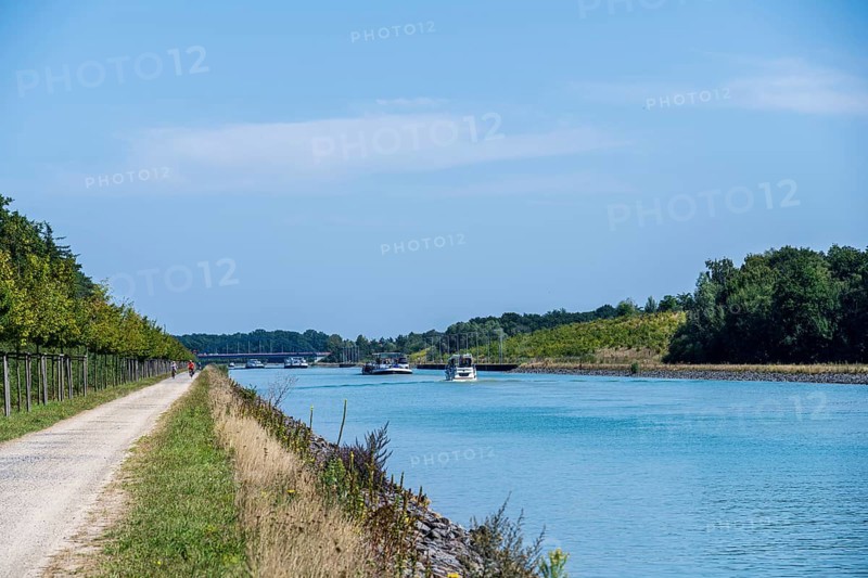 Canal with boats and clear sky. Calm water surrounded by nature and a gravel path, Dortmund-Ems Canal near Lüdinghausen, Münsterland, North Rhine-Westphalia