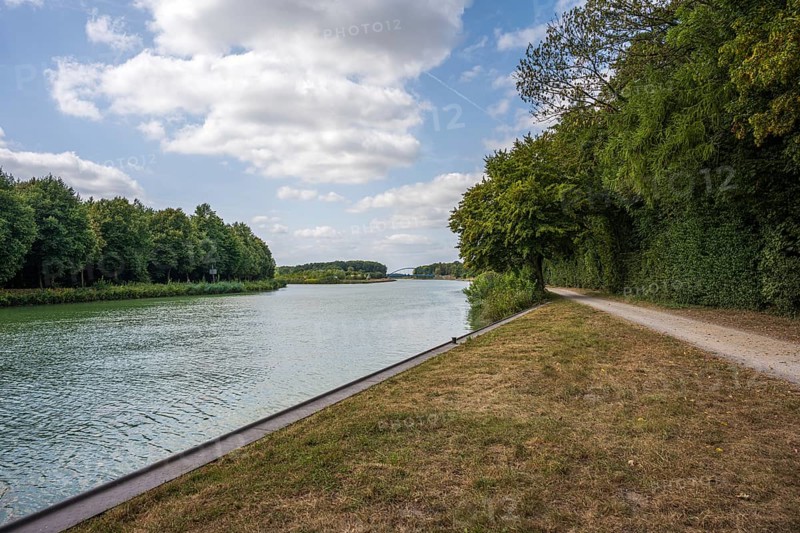 Idyllic river with adjoining path, framed by trees under a partly cloudy sky, Senden, Münsterland, North Rhine-Westphalia, Germany