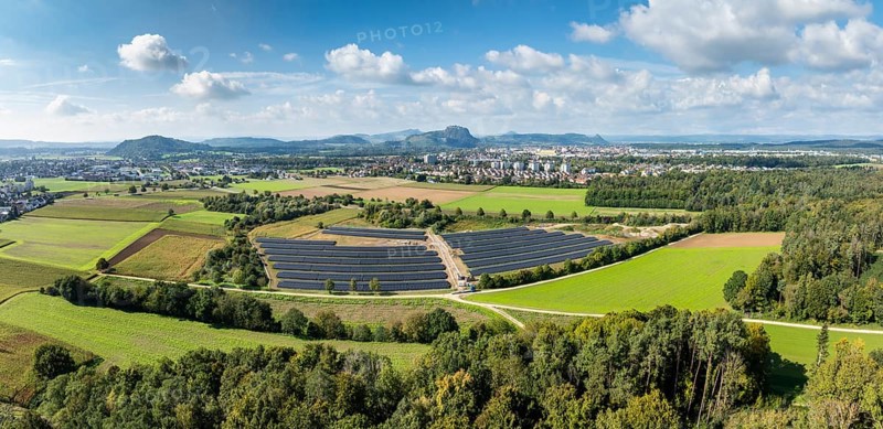 Aerial view, panorama, solar modules, solar park, photovoltaics, power generation from solar energy, behind the city of Singen am Hohentwiel, on the horizon the Hegau mountains, district of Constance, Baden-Württemberg, Germany