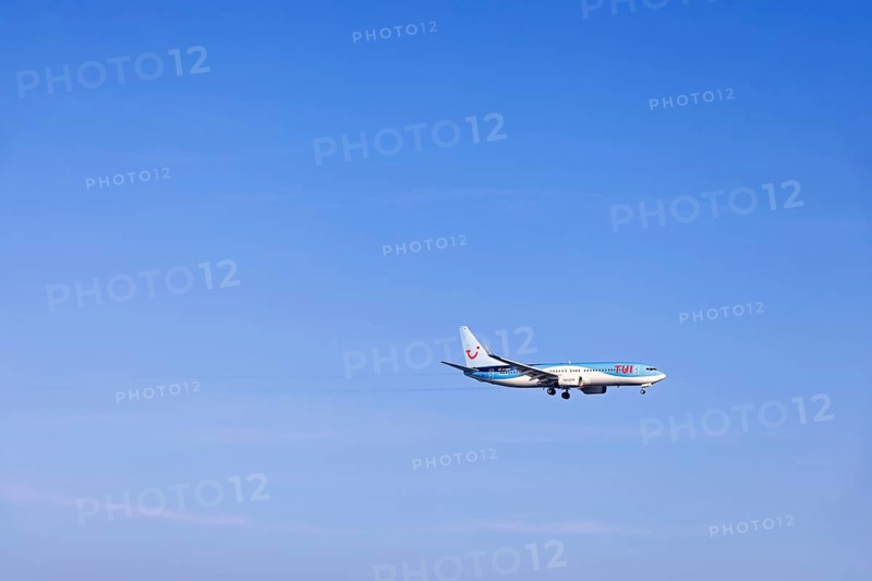 Passenger plane with tourists from the travel company Tui flying on a clear blue sky, Mallorca, Spain
