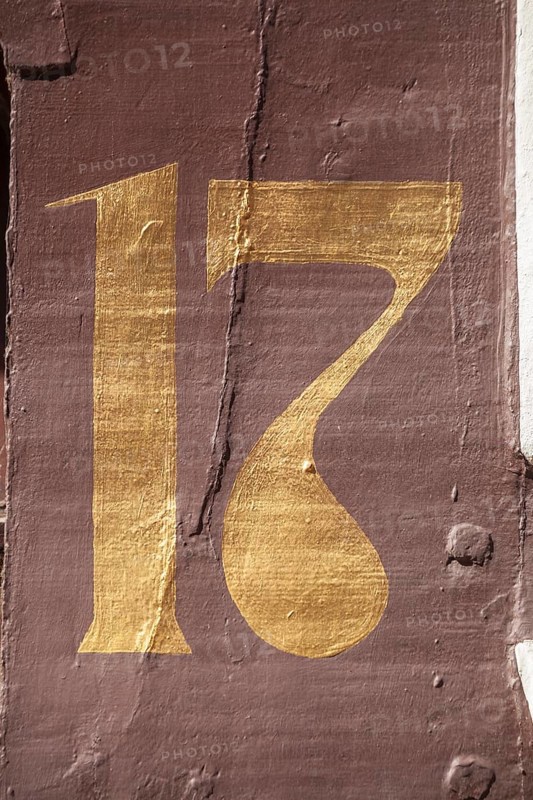 Golden house number plate number seventeen on a half-timbered house in the old town centre, Hamelin, Lower Saxony, Germany