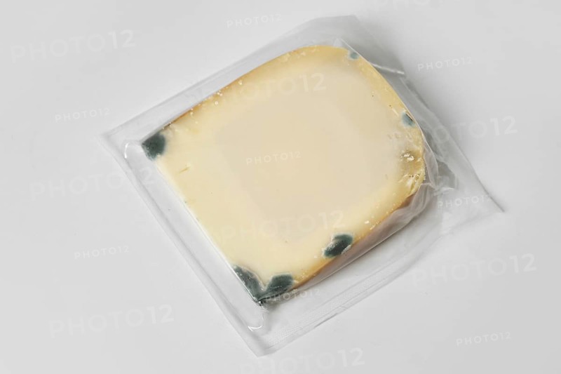 Sealed block of moldy goat cheese in packaging
