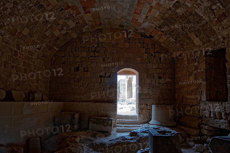 Dark room in ancient stone ruin with vault and doorway leading into the light, Acropolis, Lindos, Rhodes, Island, Greece