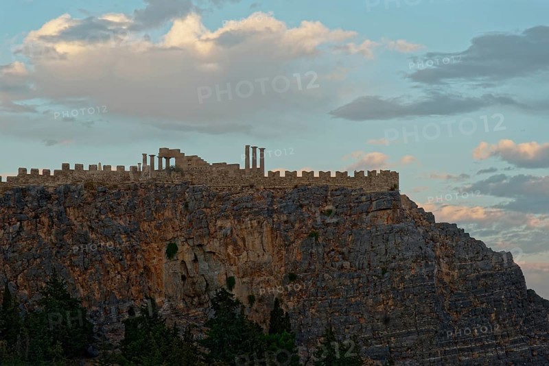 The ancient Acropolis of Lindos on jagged rocks against a dramatic sky at dusk, Acropolis, Lindos, Rhodes, Island, Greece