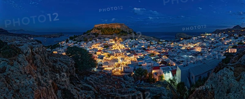Panorama of picturesque Lindos and the ancient Acropolis at night with illuminated buildings and sea, Acropolis, Lindos, Rhodes, Island, Greece