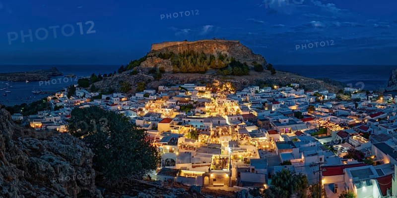 Illuminated town of Lindos with the ancient acropolis and sea in the background, surrounded by rocks, Acropolis, Lindos, Rhodes, Island, Greece