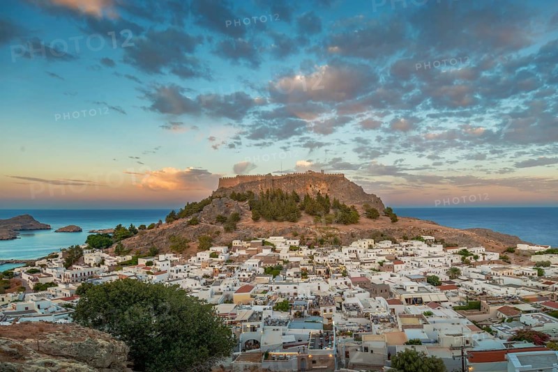 View of picturesque Lindos with the ancient Acropolis on a hill surrounded by the sea at sunset, Acropolis, Lindos, Rhodes, Island, Greece