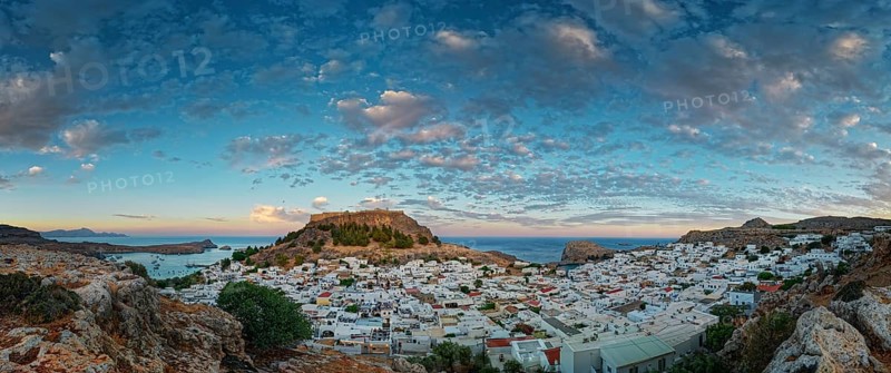 Picturesque Lindos with the ancient Acropolis in the evening light, surrounded by rocks and sea with a dramatic cloudy sky, Acropolis, Lindos, Rhodes, Island, Greece