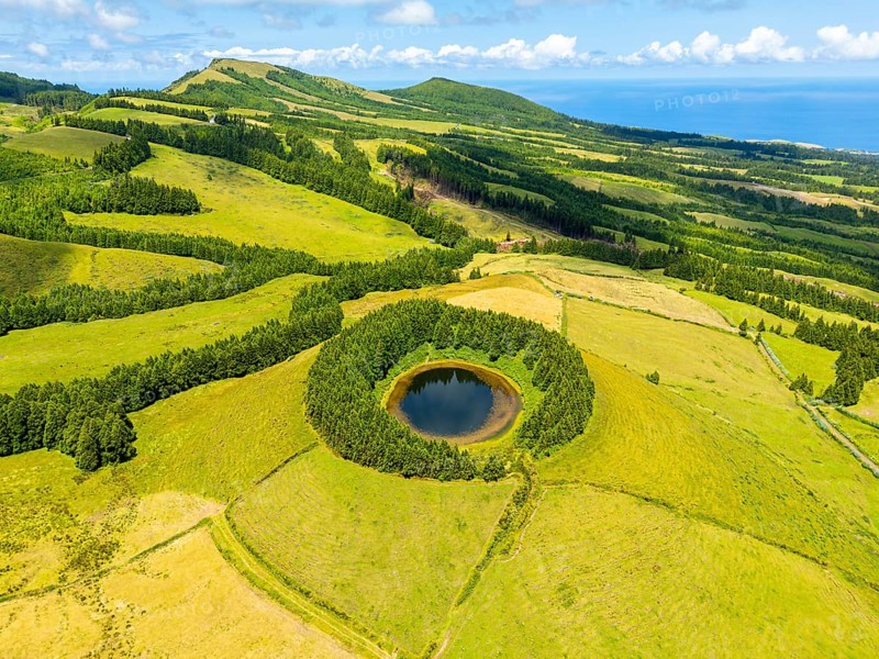 Lake Pau Pique and Lush Green Hills with Pastureland and Trees. Atlantic Ocean. Azores, Sao Miguel Island. Portugal. Aerial View