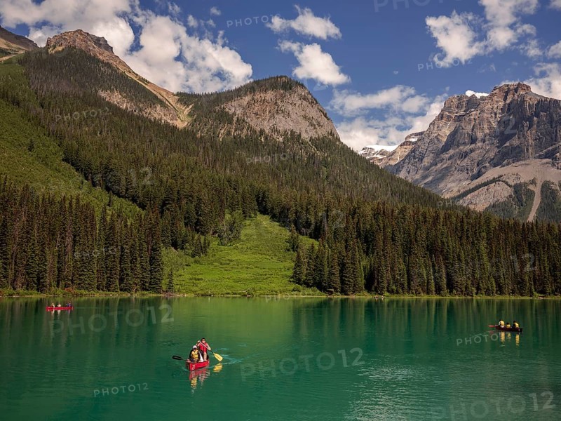 A group canoeing on Emerald Lake with the dramatic Canadian Rocky Mountains as a scenic backdrop within Yoho National Park in Alberta, Canada, North Canada