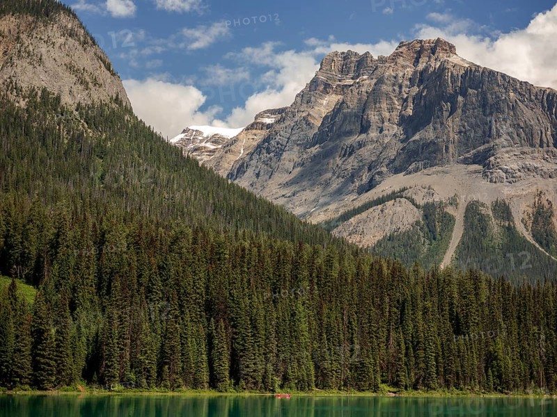 Scenic view of Emerald Lake and the Canadian Rocky Mountains with a dense forest backdrop within Yoho National Park in Alberta, Canada, North Canada