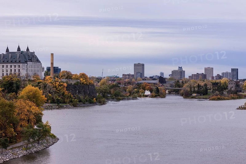 A city skyline seen across a the Ottawa River during an overcast autumn day in Ottawa, Ontario, Canada, North America