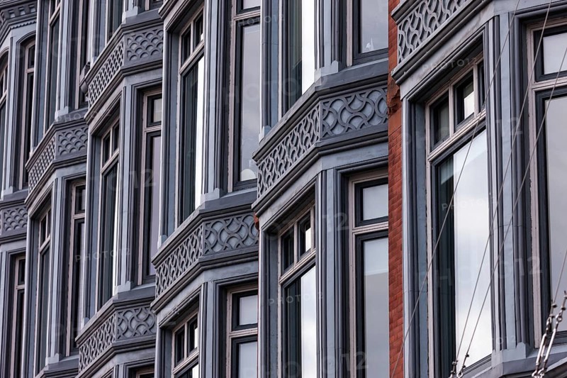 Facade of a building with a series of windows and intricate architectural designs, reflecting a structured urban style in Ottawa, Ontario, Canada, North America