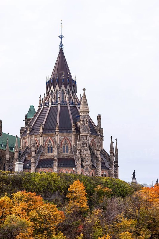 The stately Canadian Parliament Buildings with their Gothic structure with a tall spire and autumn foliage, capturing both architectural and seasonal beauty in Ottawa, Ontario, Canada, North America