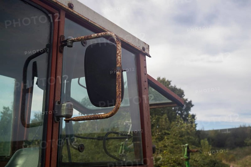 Borken, NRW, Germany, Rusty cabin and side mirror of an old agricultural tractor showing rural decay