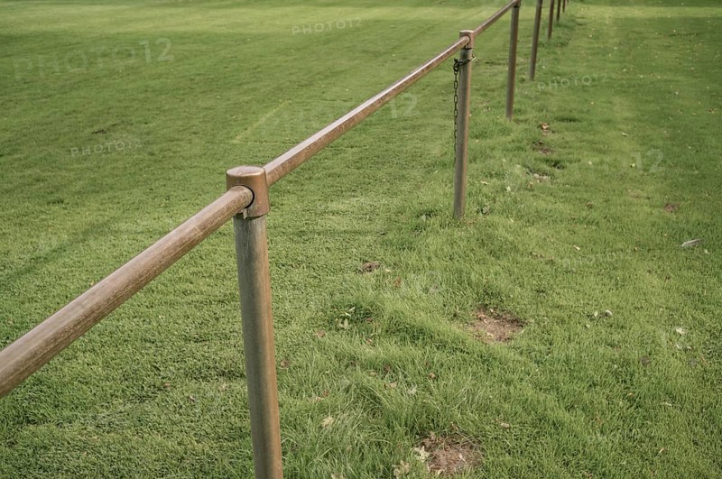 Borken, NRW, Germany, Metal railing creating a barrier along the edge of a lush green grass field