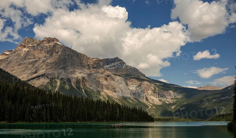 Serene mountain view of the Canadian Rocky Mountains with clear Emerald Lake reflecting a dramatic sky and lush forest inside Yoho National Park, British Columbia, Canada, North America