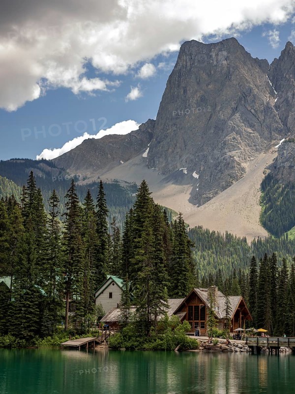 Cabin by a tranquil Emerald Lake with towering mountains of the Canadian Rocky Mountains and a dramatic sky inside Yoho National Park, British Columbia, Canada, North America