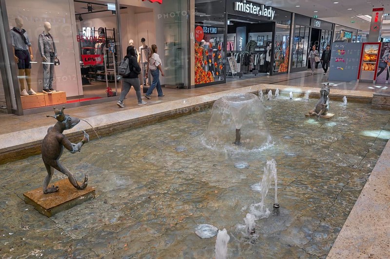 Shops and fountain with frog king in Forum Allgäu, Kempten, Allgäu, Swabia, Germany