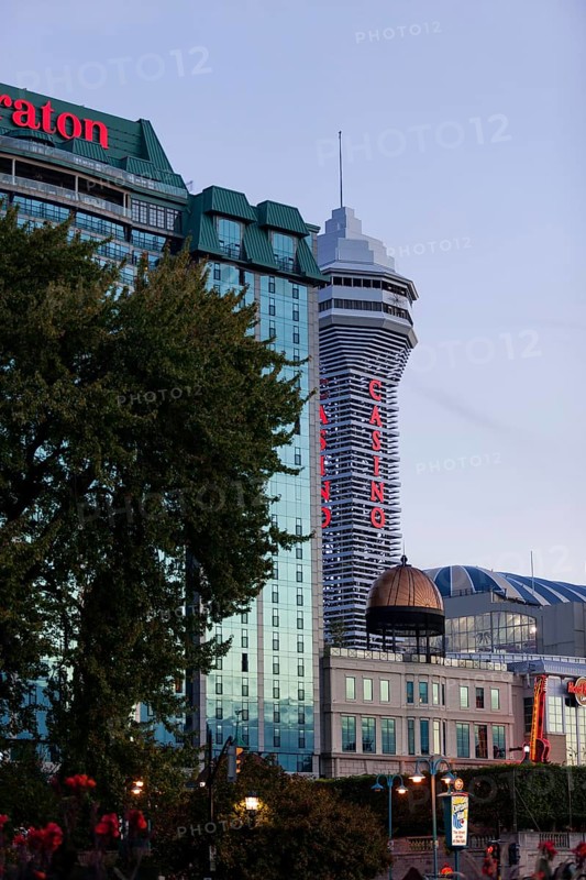 Tall hotel and casino buildings with bright signage against an evening sky in Niagara Falls, Ontario, Canada, North America