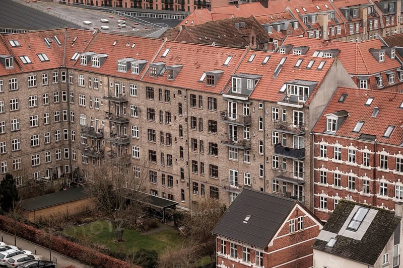 View of apartment buildings with red tile rooftops under a cloudy sky in Aarhus, Denmark, Northern Europe