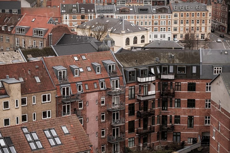 Cityscape featuring residential buildings with red tile roofs under an overcast sky in Aarhus, Denmark, Northern Europe