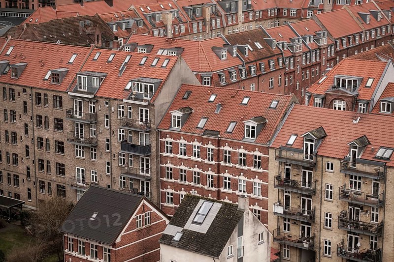 Urban scene showcasing densely packed buildings with red tile roofs on a cloudy day in Aarhus, Denmark, Northern Europe
