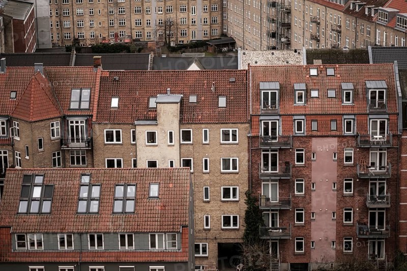 Close-up of red-tiled residential buildings with various windows and balconies in an urban setting in Aarhus, Denmark, Northern Europe