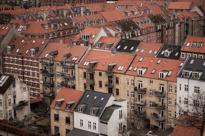 View of a residential area with red-tiled rooftops and brick buildings under a cloudy sky in Aarhus, Denmark, Northern Europe