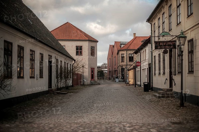 An empty street lined with buildings under a cloudy sky, vintage signs adding to the quiet atmosphere in Helsingborg, Sweden, Scandinavia, Northern Europe