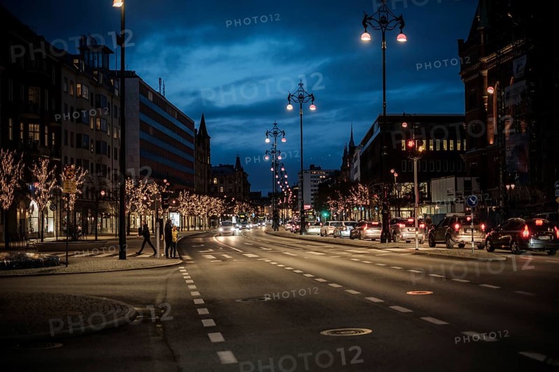 Nighttime urban road lined with illuminated trees and passing cars in Helsingborg, Sweden, Scandinavia, Northern Europe