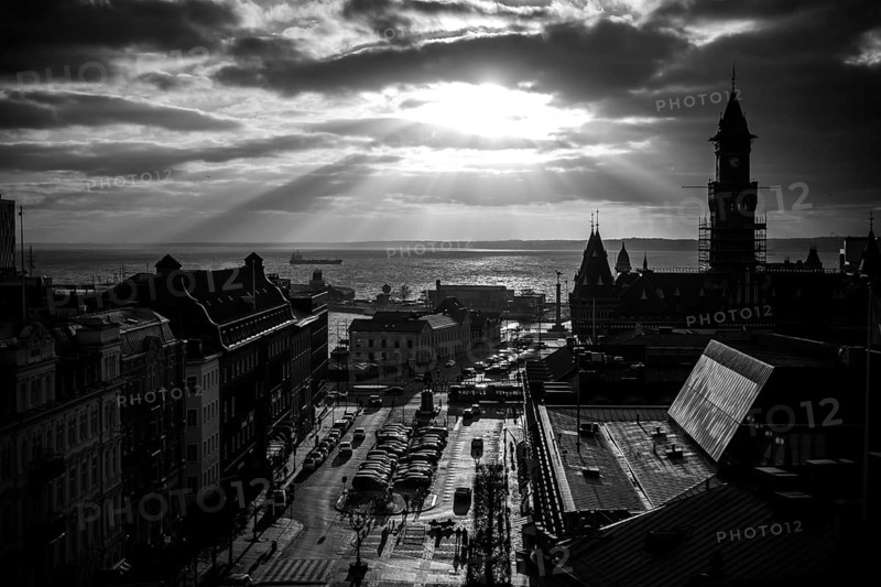 Black and white cityscape with dramatic clouds and sunlight over a harbor and buildings and looking out to the Oresund Strait, between Sweden and Denmark, as seen from Helsingborg, Sweden, Scandinavia, Northern Europe