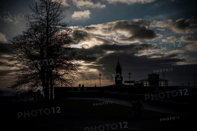 Silhouette of figures and a tower at sunset with a dramatic cloud-filled sky in Helsingborg, Sweden, Scandinavia, Northern Europe
