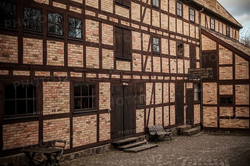 Historic brick building with wooden beams and benches, featuring cobblestone pavement in Helsingborg, Sweden, Scandinavia, Northern Europe