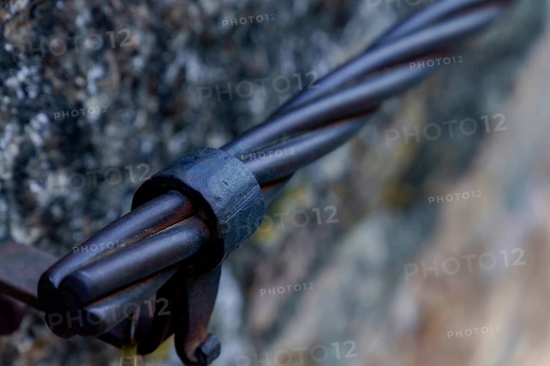 Steel cable railing showing a strong metal connection detail on a stone wall in ronda, malaga, spain