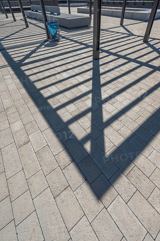 Concrete pavement, blue rubbish bin, long shadows at the state vocational school, Kempten, Allgäu, Swabia, Germany