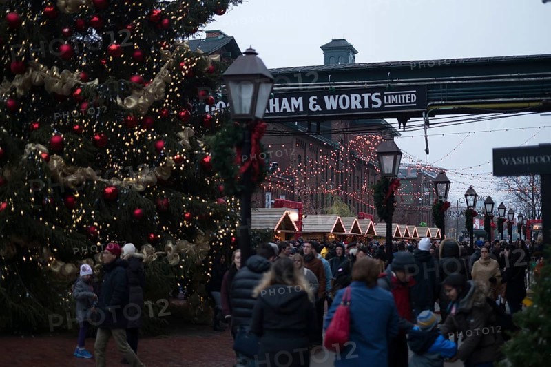 A bustling outdoor Christmas market at the Gooderham and Worts Distillery District, with festive lights and decorations in Toronto, Ontario, Canada, North America