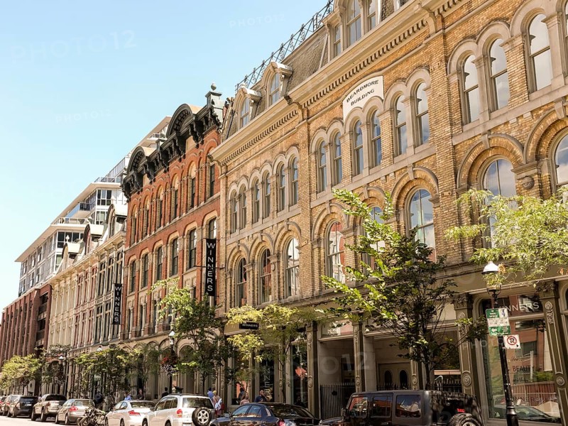 Street view of historic buildings with trees and parked cars in Toronto, Ontario, Canada, North America