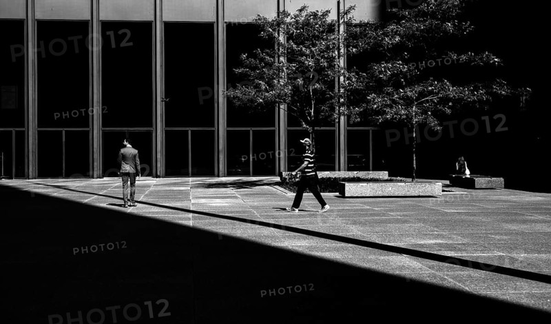 People walking in a modern urban environment with a balance of light and shadow, creating a dynamic city scene in Toronto, Ontario, Canada, North America