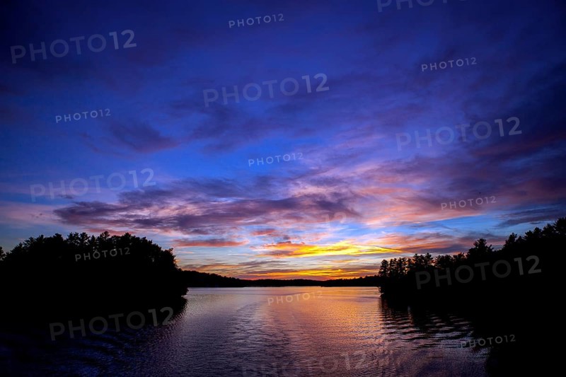 Serene lake at sunset with colorful sky reflections creating a peaceful landscape in Muskoka, Ontario, Canada, North America