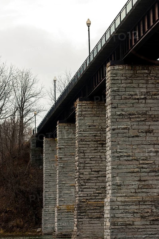 Image of a bridge with massive stone columns under an overcast sky, creating a somber industrial feel in St. Marys, Ontario, Canada, North America