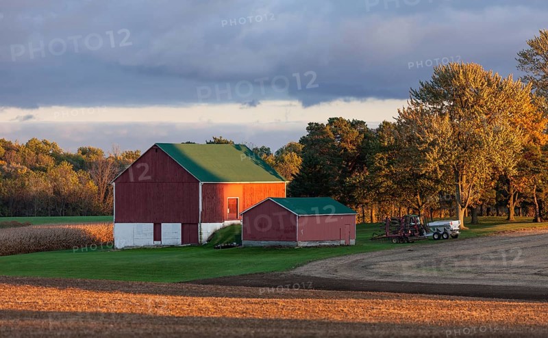 Red barn and fields illuminated by warm sunset in St. Thomas, Ontario, Canada, North America