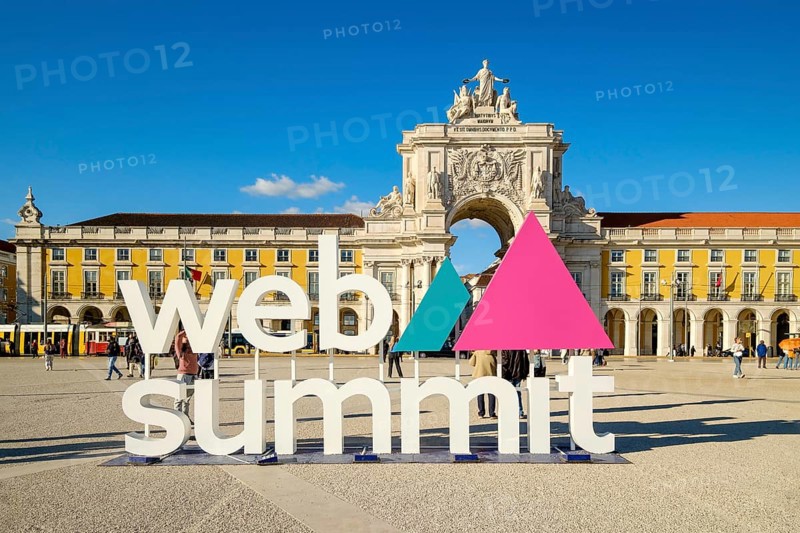 Nov 13, 2024 - Lisbon, Portugal: Web Summit installation in Praca do Comercio with famous Rua Augusta Arch and historic yellow buildings on sunny day. Technology and historic heritage, global event, innovation, entrepreneurship, future of technology