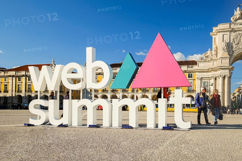Nov 13, 2024, Lisbon, Portugal: Colorful Web Summit sign against classic architecture of Praca do Comercio. Internet technology, emerging technology, marketing, AI solutions, innovation and networking, discussions on technology and ideas