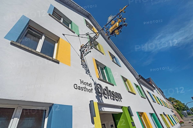 Blue sky, Hotel-Gasthof-Ochsen with nose sign and colourful windows in Kisslegg, Allgäu, Baden-Württemberg, Germany