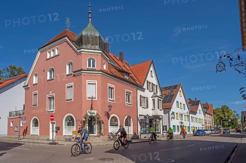Blue sky, street with cyclists, pointed gable houses and ZAPPA BAR in Kisslegg, Allgäu, Baden-Württemberg, Germany