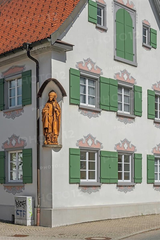Blue sky, pointed gable house with green shutters and bishop figure, Kisslegg, Allgäu, Baden-Württemberg, Germany