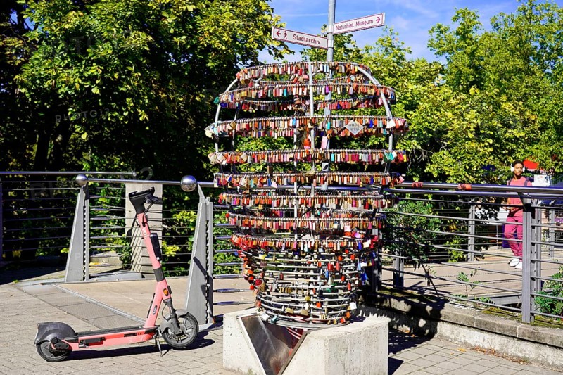 Electric scooter next to a large heart made of padlocks outdoors, Nuremberg, Middle Franconia, Franconia, Bavaria, Germany