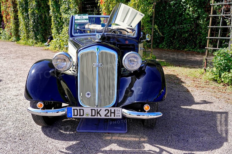 Oldtimer Classic, Gala International Concours d'Elegance Schwetzingen 2025, Germany, Europe, A blue classic car stands on a gravel path next to green trees in the sunlight