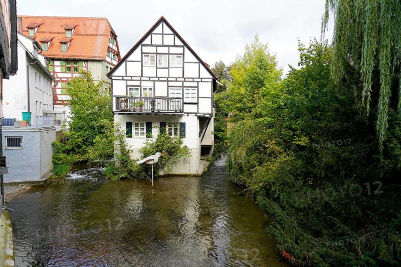 The picturesque fishermen's quarter in Ulm with its beautiful half-timbered houses on the Blau, half-timbered house with balcony on a small river, surrounded by lush greenery, Ulm, Germany